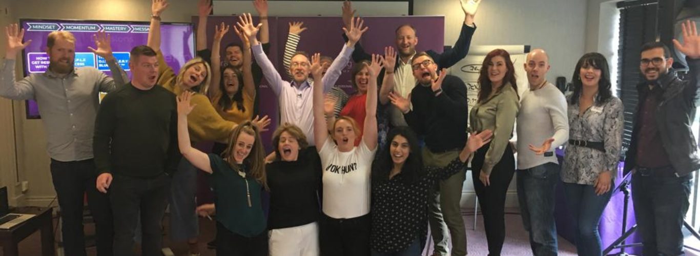NLP training group cheering at an event